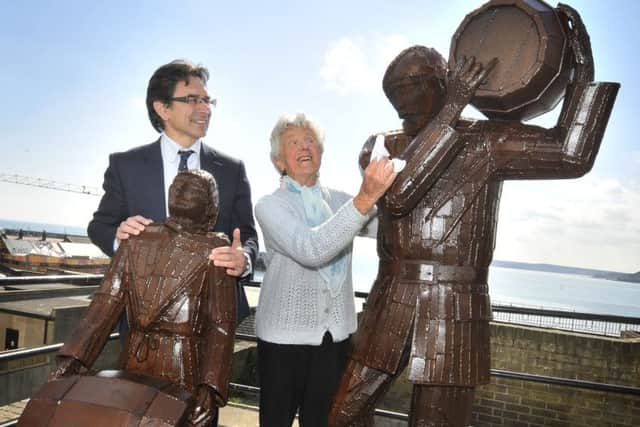 Editor Ed Asquith and  Maureen Robinson admire the newly  polished Smugglers statue in Merchants row. 162101a