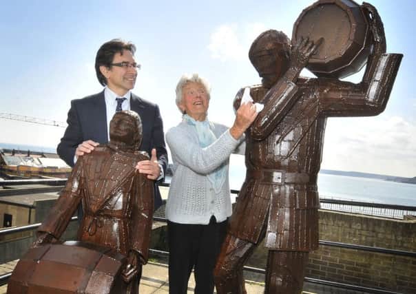 Editor Ed Asquith and  Maureen Robinson admire the newly  polished Smugglers statue in Merchants row. 162101a