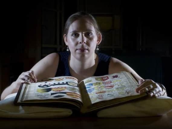Rebecca Dowd, data migration assistant at Leeds University Special Collections, with a heraldic manuscript of the Horseley Family of York from 1659; and among the archives. Picture: James Hardisty