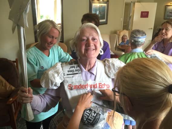 Resident Mary Richardson enjoys drsssing up in old Echo newspapers.