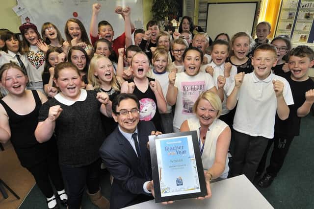 Scarborough News Editor Ed Asquith presentsTeacher of the year winner Dee McCulloch with her award as her class cheer with joy. . pic Richard Ponter 163101d