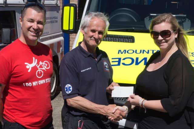 Neil and Becky Robinson present the cheque to Roger Hartley (centre) during the Mountain Rescue Team open day.