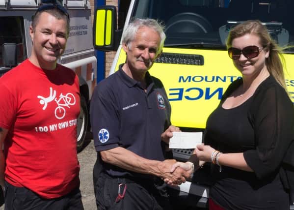 Neil and Becky Robinson present the cheque to Roger Hartley (centre) during the Mountain Rescue Team open day.