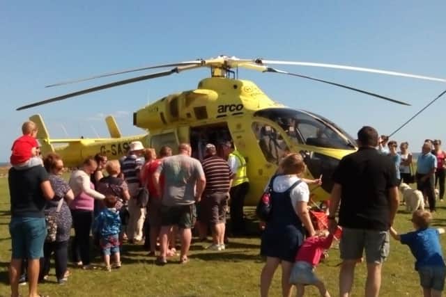 Crowds at Filey Country Park take a look around the Yorkshire Air Ambulance helicopter