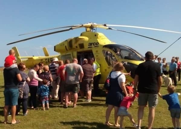 Crowds at Filey Country Park take a look around the Yorkshire Air Ambulance helicopter