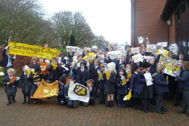Children wave their banners and posters.