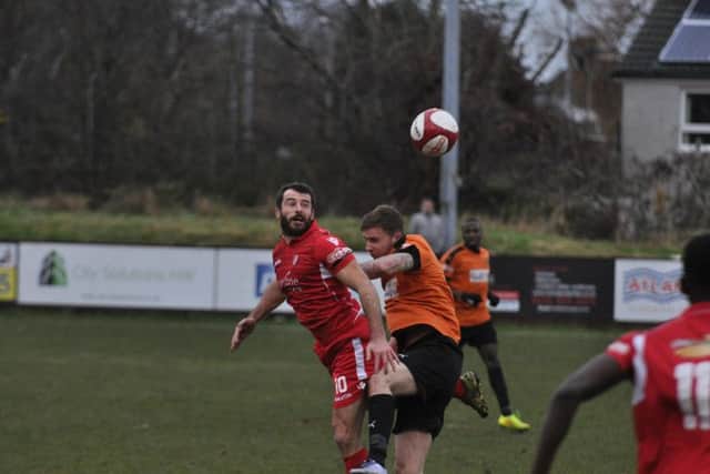 Adam Bolder wins a header at Prescot