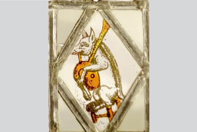Piping pig stained glass window is one of a set of four on display in the Rotunda Museum in Scarborough.