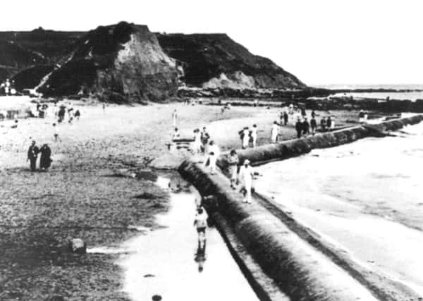 A view of the beach area at Scalby Mills. The strange looking mound in the centre of the picture was known as 'Monkey Island' a popular playground for many generations.
Visitors are taking advantage of low tide as they walk along the old Victorian outfall pipes which stretched as far as Jackson's Bay to the north.
Photo reproduced courtesy of the Max Payne collection. 
Reprints can be ordered with proceeds going to local charities. Telephone 0330 1230203 and quote reference number