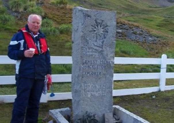 Heritage centre president Martin Johnson is pictured next to Ernest Shackeltons grave in South Georgia.