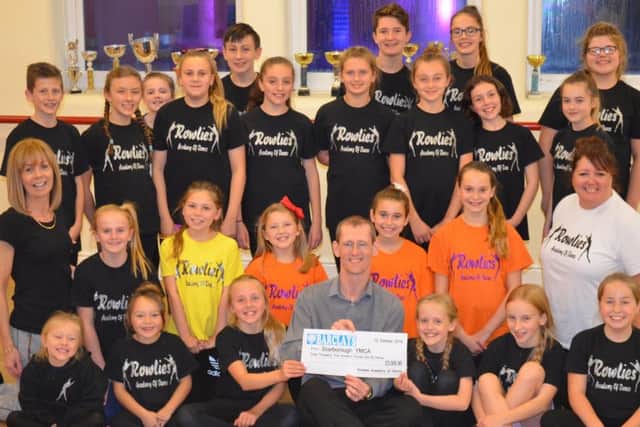 Julie Nockels, second row, left and Joanne Hall, second row, right, with some of the Musical Mashup cast presenting a cheque to Steve Marsh (seated centre front).