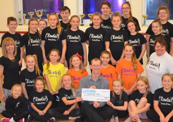 Julie Nockels, second row, left and Joanne Hall, second row, right, with some of the Musical Mashup cast presenting a cheque to Steve Marsh (seated centre front).