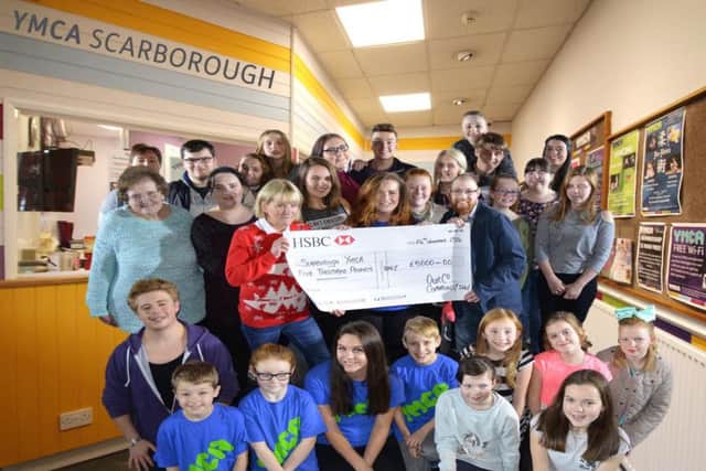 Veronica Thorpe and Matty Gledhill present the OurCo cheque to Katie Doubtfire (centre), surrounded by members of Scarborough YMCA.