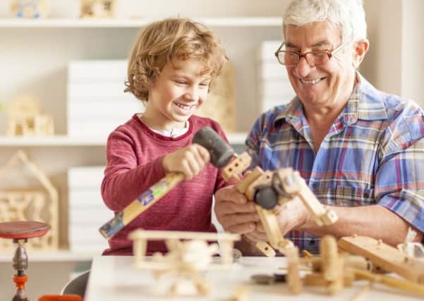 Grandpa and his grandson crafting wooden toys together in a workshop