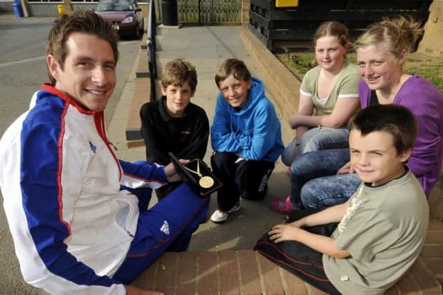 Former Olympic swimmer Chris Cook (left) shows his gold medal to Filey School pupils in 2010. Cook will be the guest of honour at this year's Sports Awards