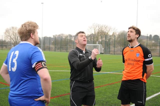 Flamborough 2nds captain James Hodgson, blue kit, and  Brid Rovers skipper Tom Broadbent look on as referee Mark Edwards tosses the coin before the first-ever game at the new 4G pitch in Bridlington