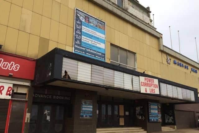 Sign pinned to the front of the theatre reads "power corruption & lies"
