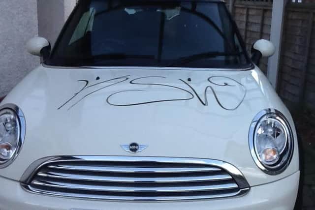The letters KSW and ZELK have been written on cars and homes