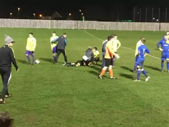 The referee receives treatment on the pitch