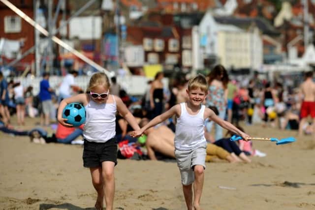 Madeleine and Bailey Doherty enjoy the beach as crowds pack onto the South Bay in Scarborough as warm weather bathed the UK at the weekend.
