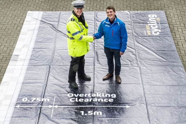 Inspector Dave Barf of North Yorkshire Police and David Murray from Cycling UK with the safe pass mat, showing the distance vehicles ought to be leaving.