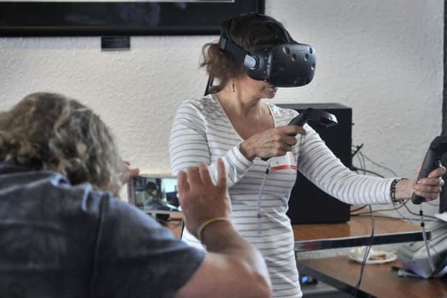 Gilly Collinson tries out one of the digital exhibition experiences at the SJT's Exploring Digital Futures