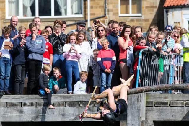 The greasy pole competition at Whitby Regatta . Saturday 18 August. Whitby Regatta 2017. Picture: Ceri Oakes w173001y