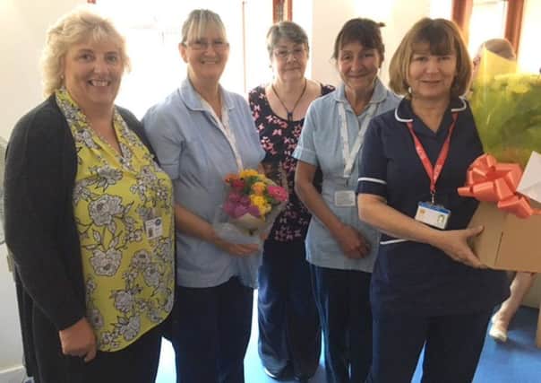 Diane Wingfield, second left, is presented with flowers and gifts as she ends her time at Saint Catherines Hospice.
