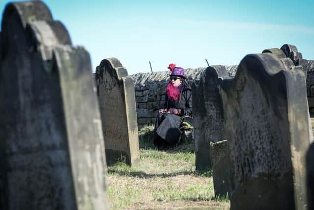 A woman admires the view from the graveyard at St Mary's Church during Whitby Goth Weekend.  Friday 27 October Picture Ceri Oakes. w174301f