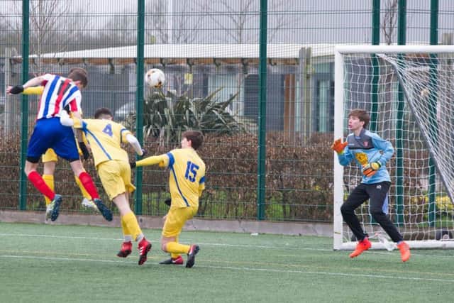 Fin March (number four) and Harry Holden cant prevent a home player heading his side into the lead during their 3-2 victory. Pictures by Andy Standing.
