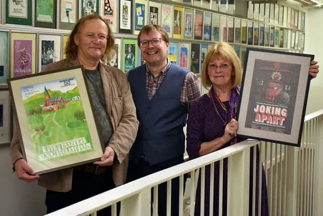 SJT Archivist Simon Murgatroyd, centre, and Mark and Enid Lamb with the two rare posters.