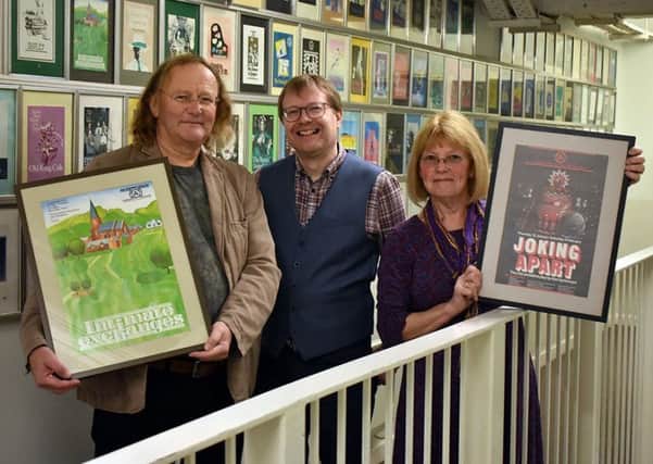 SJT Archivist Simon Murgatroyd, centre, and Mark and Enid Lamb with the two rare posters.