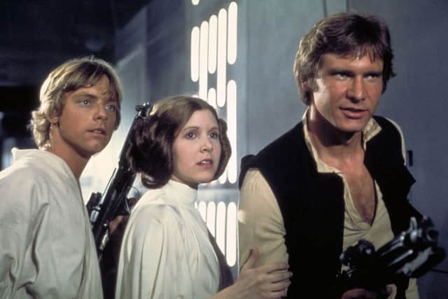 Actors, from left, Mark Hamill as Luke Skywalker, Carrie Fisher as Princess Leia and Harrison Ford as Han Solo, appear in a scene from Lucasfilm's "Star Wars: Episode IV, A New Hope,.