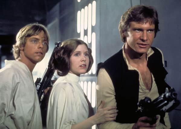 Actors, from left, Mark Hamill as Luke Skywalker, Carrie Fisher as Princess Leia and Harrison Ford as Han Solo, appear in a scene from Lucasfilm's "Star Wars: Episode IV, A New Hope,.