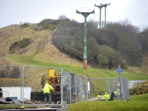 Workmen remove old chairlift pylon