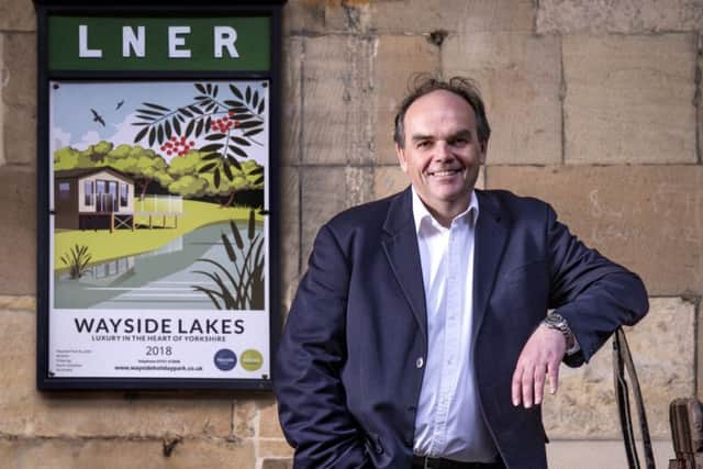 Mark Goodson stands next to the new Wayside poster at Pickering Station.
