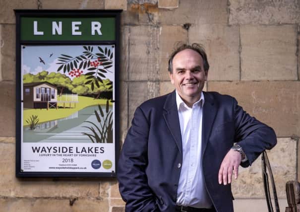 Mark Goodson stands next to the new Wayside poster at Pickering Station.