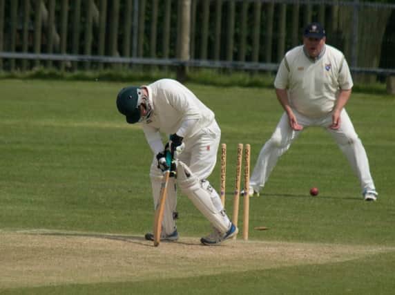 Cayton 2nds' Josh Brown falls victim to a Jonathon Atkinson delivery. Picture by Steve Lilly.