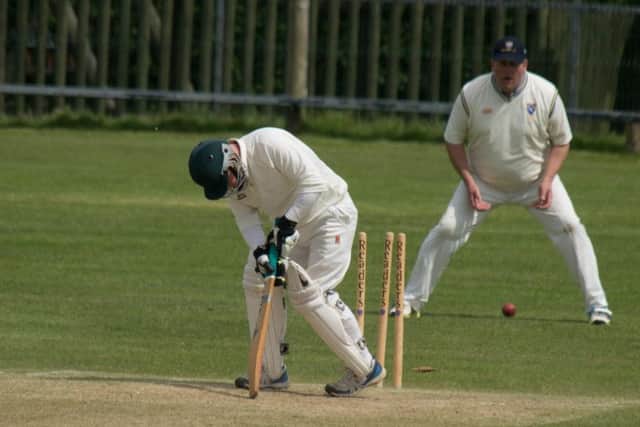 Cayton 2nds' Josh Brown falls victim to a Jonathon Atkinson delivery. Picture by Steve Lilly.